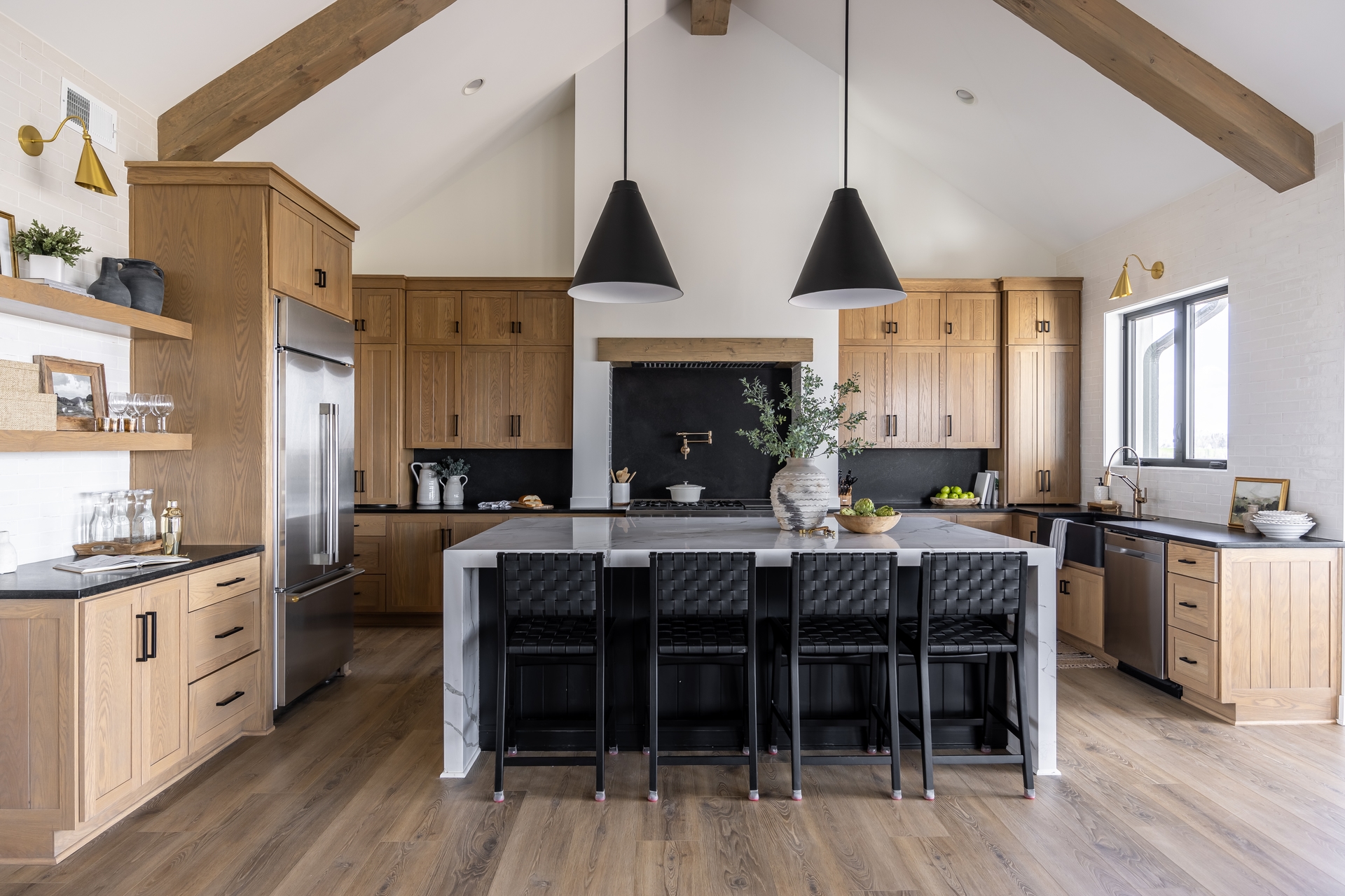 Vaulted-ceiling chef's kitchen with wood beams and a marble island